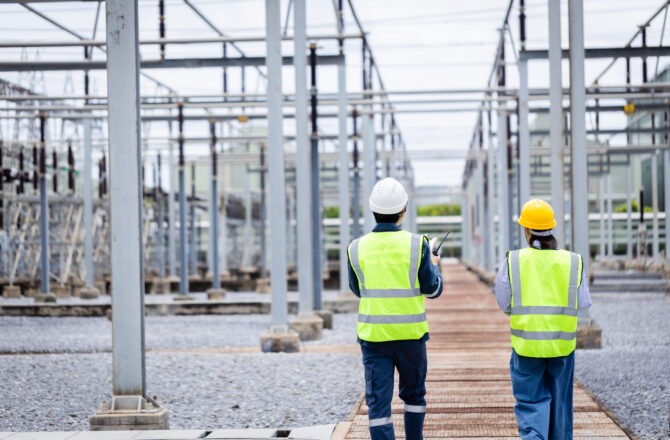 Engineers inspecting a high-voltage power substation
